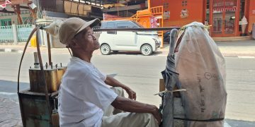 SM/Dok : Tirto Sumeto alias Pak Tir yang membawa gerobak pikul sederhana sedang berhenti menunggu pembeli di tepi jalan